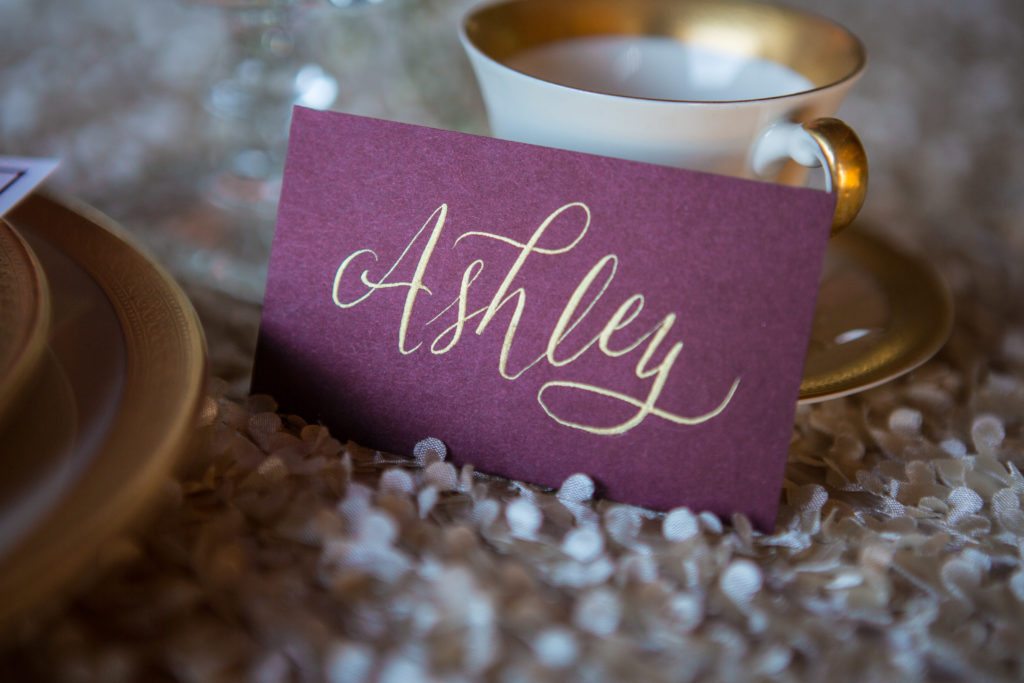 marsala escort card with gold calligraphy