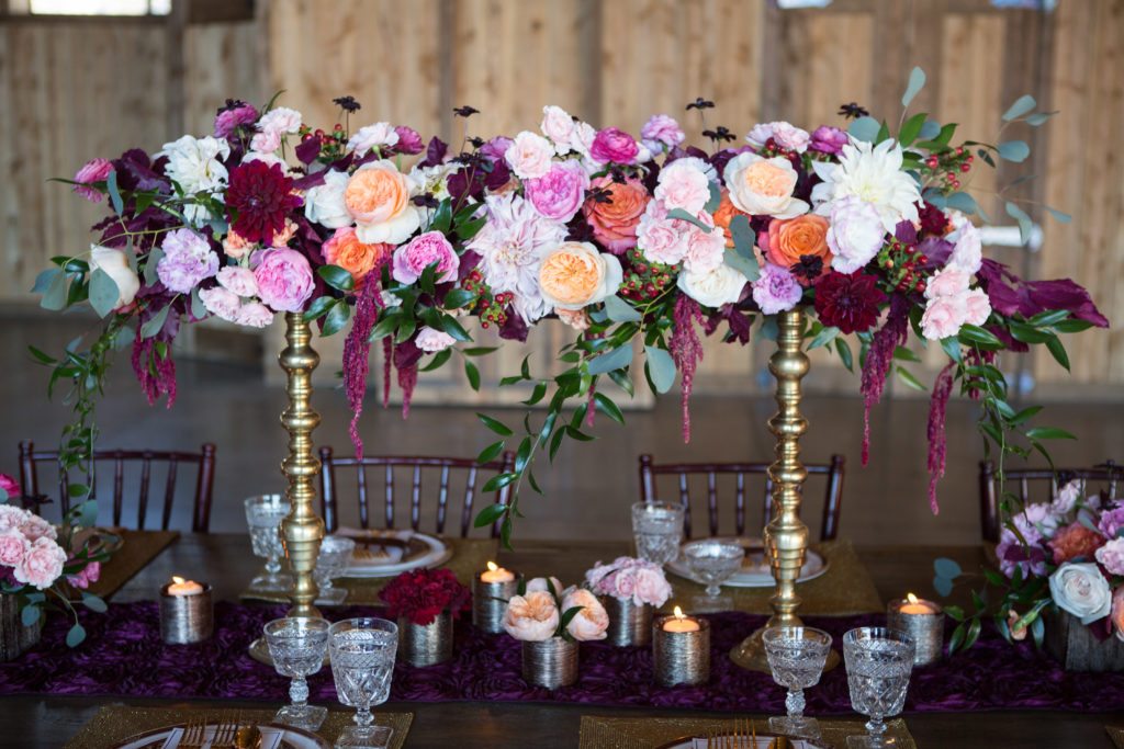tall gold centerpieces in pops of red, coral and pink