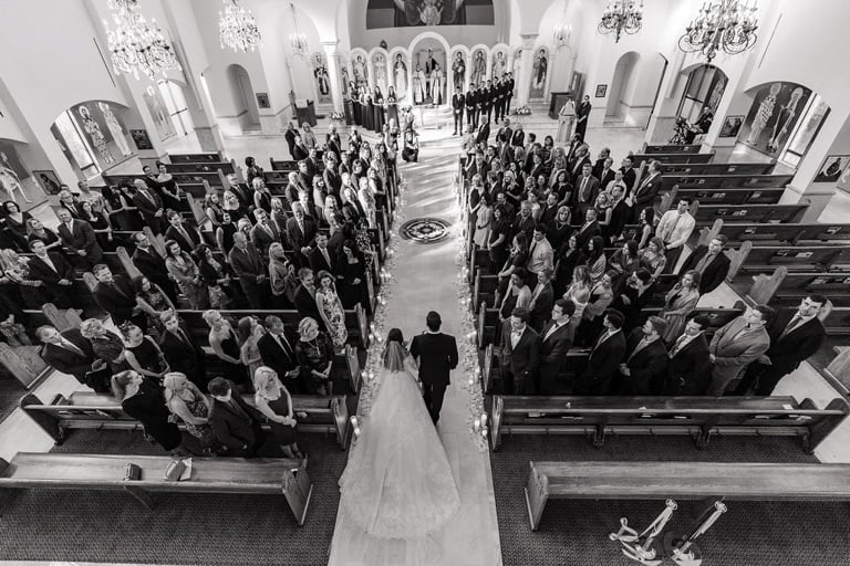 Black and white photo of bride walking down the aisle at St. Catherine Greek Orthodox Church.