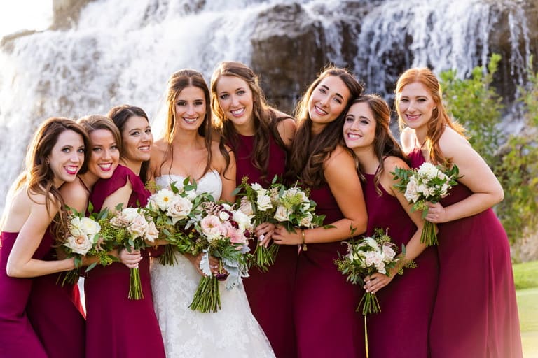 Melanie and her bridesmaids infront of a waterfall.