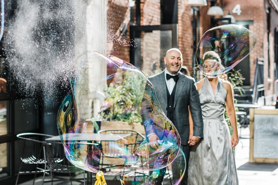 Hillary and Shawn walk to The Alley while giant bubbles cascade down