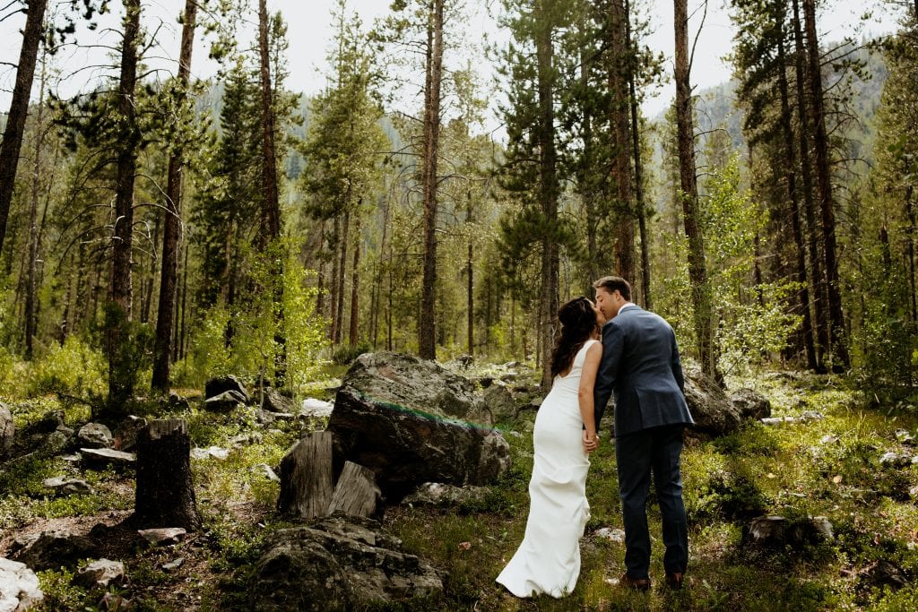 Bride and groom walk in the woods.