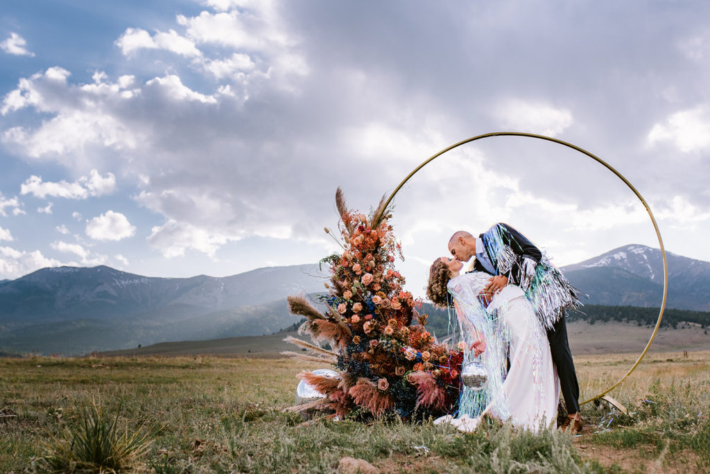70's disco wedding ceremony arch with colorado mountains in the background