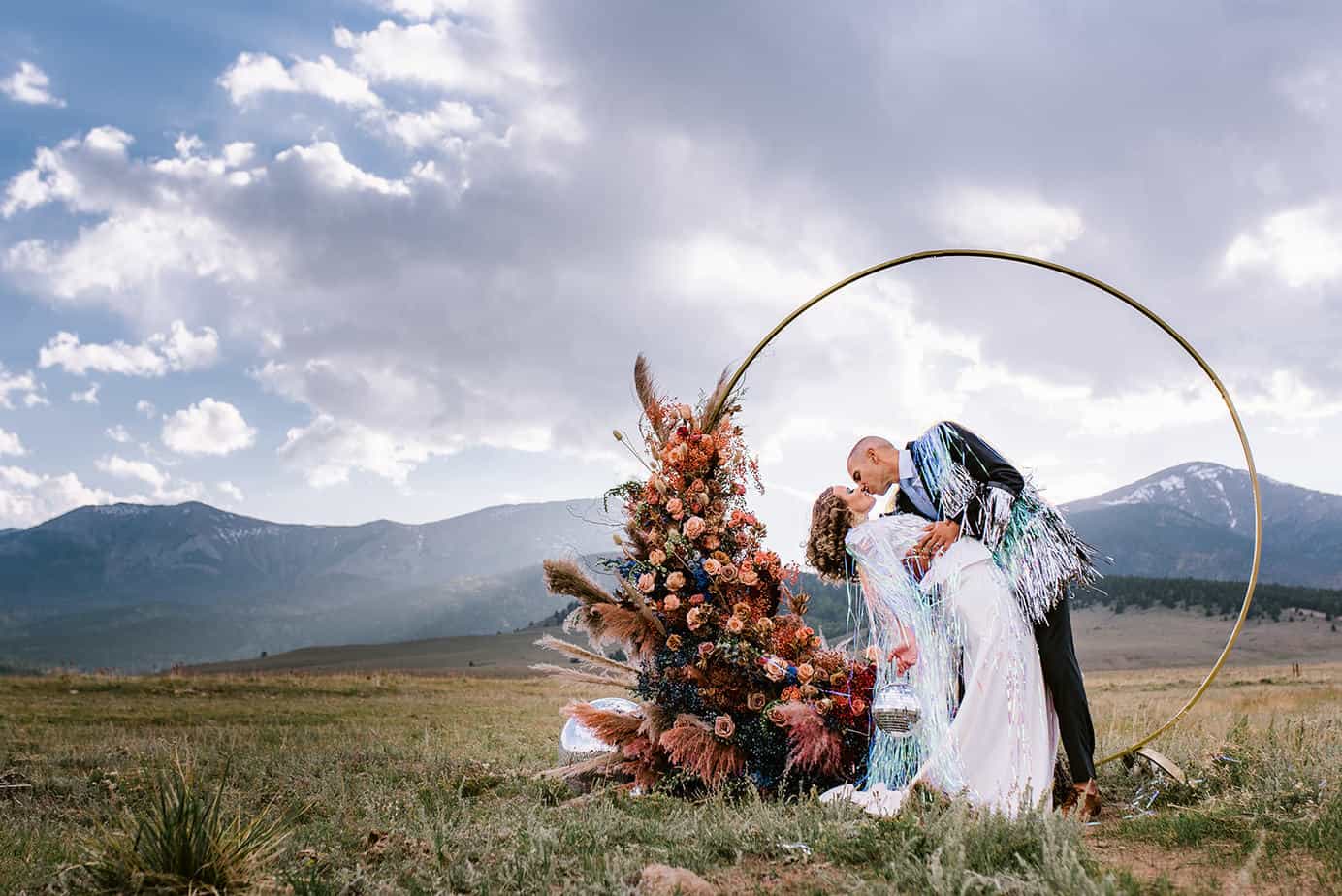 70's disco wedding ceremony arch with colorado mountains in the background