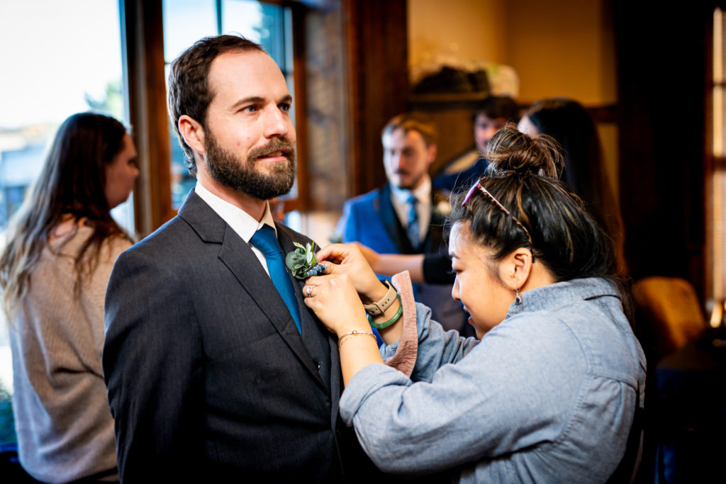 wedding planner assisting with boutonniere